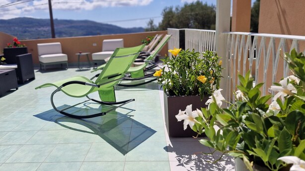 A rooftop terrace with outdoor seating, including chairs and tables, and potted plants. - marte rooms (San Nicola)