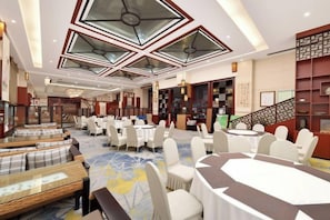 A hotel lobby with round tables, white chairs, and a patterned carpet. - Xiyuan Jinrun Hotel (Guiyang Huaxi Xiaohe Branch) (Guiyang)
