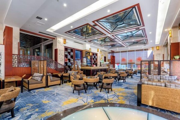 A hotel lobby with seating areas, a reception desk, and a large glass ceiling. - Xiyuan Jinrun Hotel (Guiyang Huaxi Xiaohe Branch) (Guiyang)
