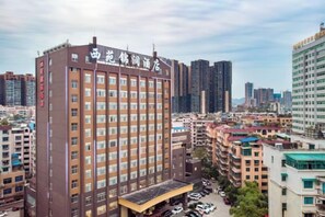 A multi-story hotel with a prominent entrance and a parking area in front. - Xiyuan Jinrun Hotel (Guiyang Huaxi Xiaohe Branch) (Guiyang)