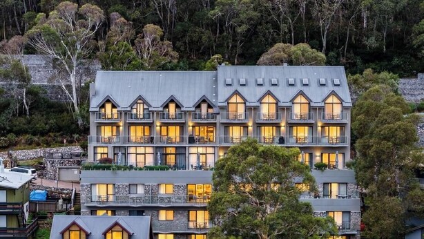 Un hotel de varios pisos con un diseño arquitectónico moderno, con balcones y ventanas amplias.