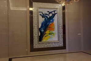 Un cuadro abstracto enmarcados en un vestíbulo con un borde estampado.