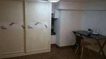 A room with a sliding door closet, a dining table with chairs, and a small potted plant.