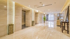 A spacious hotel lobby with a marble floor, a reception desk, and a large window. - Ziyu International Holiday Hotel (Chengde)