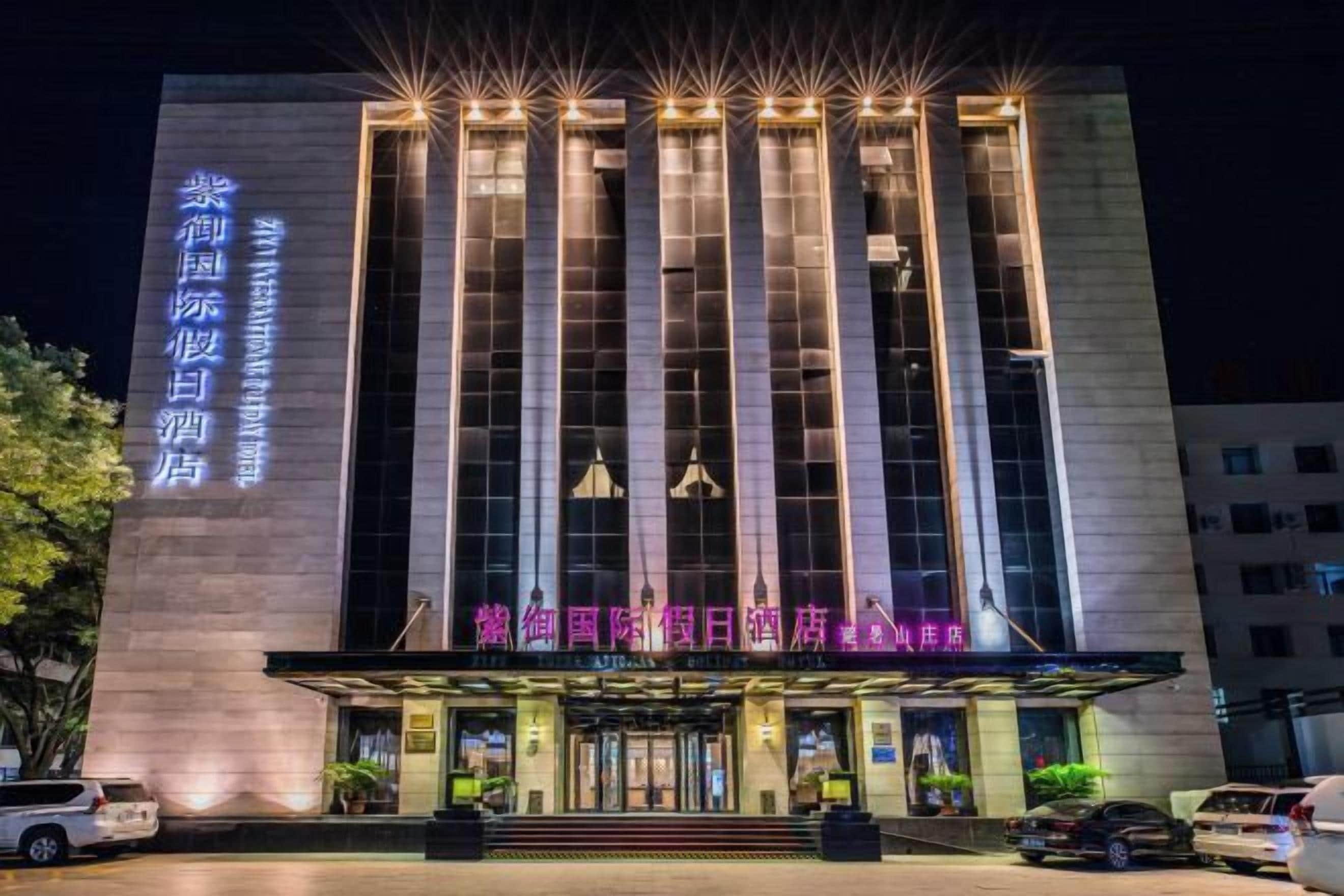 A hotel with a prominent vertical facade and illuminated signage.