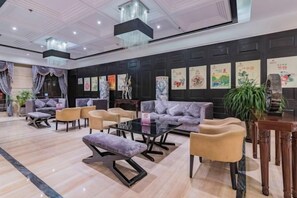 Un vestíbulo de hotel con sofás, sillones y una mesa de centro.