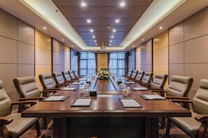 A conference room with a long table, chairs, and a floral arrangement.