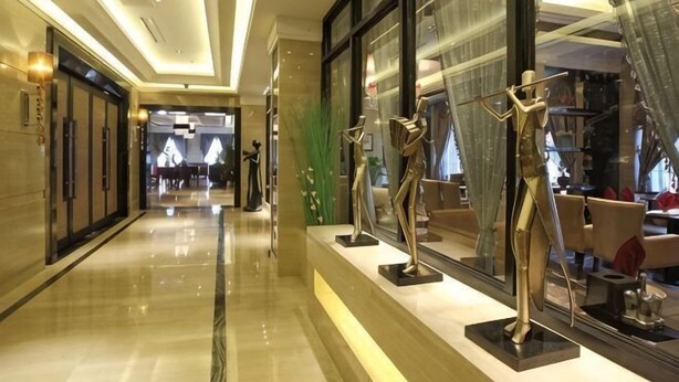 A hotel corridor with a polished floor, large windows, and mannequins displaying clothing. - Ziyu International Holiday Hotel (Chengde)