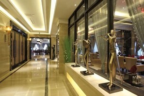 A hotel corridor with a polished floor, large windows, and mannequins displaying clothing. - Ziyu International Holiday Hotel (Chengde)