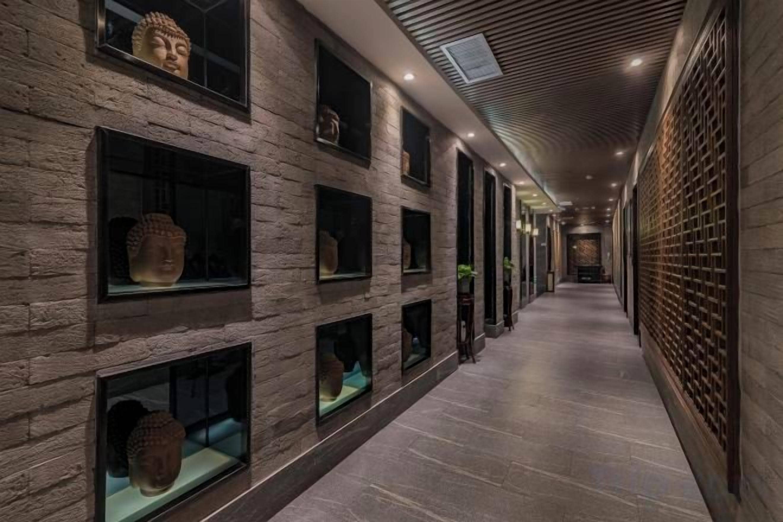 Un pasillo con paredes de piedra y varias vitrinas que exhiben artefactos.