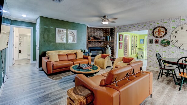 A modern living room with a brown leather sofa, a round coffee table, and a fireplace.