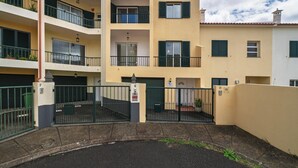 Un immeuble résidentiel à plusieurs étages, doté de balcons, d’une entrée sécurisée et surplombant un ciel dégagé.