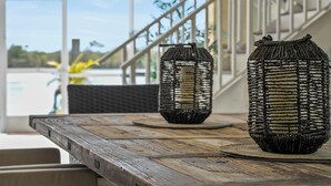 Ein Holztisch mit gewebten Laternen und Blick auf eine Treppe sowie einen Außenbereich.