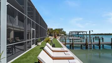 A poolside area with lounge chairs and a view of the water.