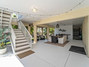 Un espace intérieur spacieux comprenant un escalier, un coin salon et une table à manger.