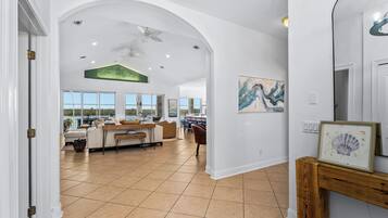 A spacious interior with a high ceiling, a dining area, and a view through large windows.