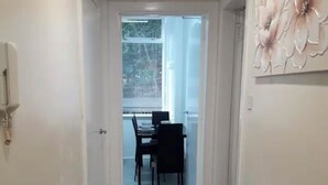 Un pasillo que conduce a un comedor con una mesa y sillas.