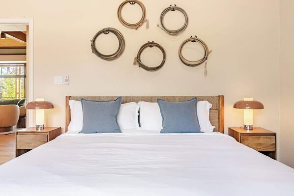 Une chambre d’hôtel comprenant un lit, deux lampes de chevet, une tête de lit et des décorations circulaires fixées au mur.