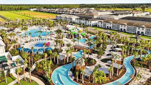 Un resort con una amplia piscina central, varias piscinas más pequeñas y una zona de parque acuático.