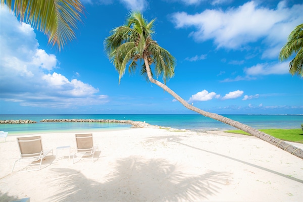 On the beach, white sand, sun loungers, beach umbrellas