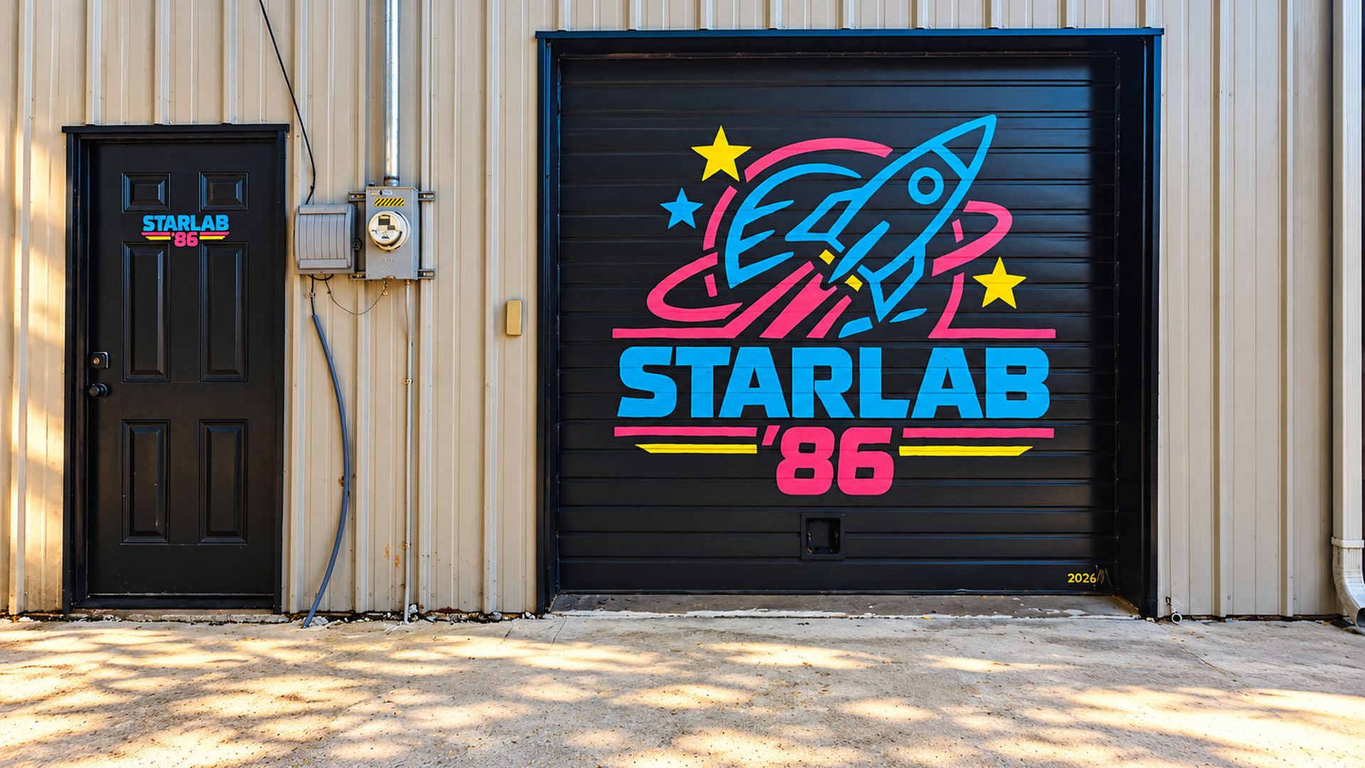 Una puerta de garaje con el logotipo colorido de StarLab '86, una puerta negra con un letrero de StarLab y una caja de servicios a la izquierda.