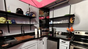 A modern kitchen with white cabinets, black countertops, and stainless steel appliances. - StarLab '86 -Downtown Pet Friendly (Fort Smith)