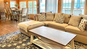 A cozy living room with a sectional sofa, a wooden coffee table, and a patterned rug.