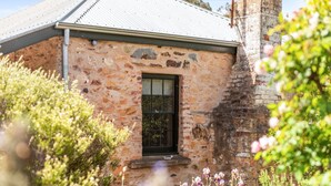 A rustic stone building with a black window and a metal roof. - Idyllic, peaceful and historical "Coath Cottage" minutes from Bendigo's CBD (West Bendigo)