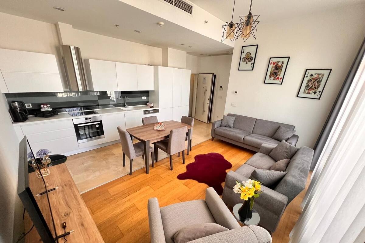 A modern apartment with a kitchen, dining area, and living room.