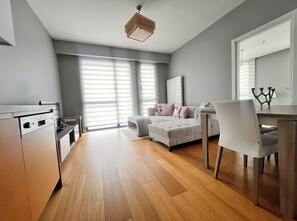 Una habitación moderna y bien iluminada, con cama, escritorio y zona de comedor.