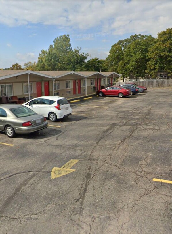 A parking lot with several cars parked in front of a row of motel-style buildings. - St Robert Towne And Village (St. Robert)