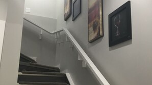 Eine Treppe mit weißer Handläufung und Teppichstufen, die zu einer Zwischenebene führen.