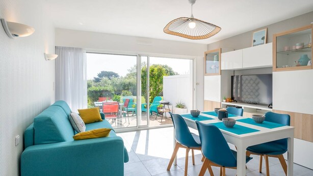 Une cuisine moderne avec un coin repas, un canapé et une vue sur le jardin.