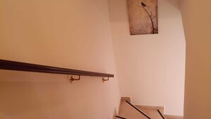 Eine Treppe mit Handlauf und einem Wandbild von einem Vogel auf einem Ast.