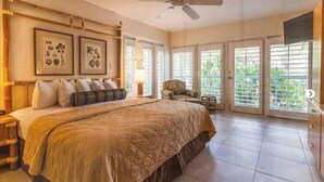 A spacious bedroom with a large bed, a ceiling fan, and a view of greenery through the sliding glass doors. - Most Beautiful View on Key West? (Key West)