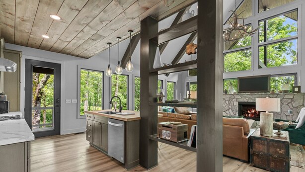 Una cocina amplia con una isla central, ventanas grandes y una chimenea de piedra.