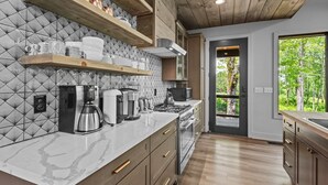 Una cocina moderna con encimeras de mármol, armarios de madera y una estufa integrada.