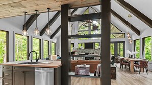 Cocina amplia con una isla central, ventanas grandes y un techo alto con vigas a la vista.