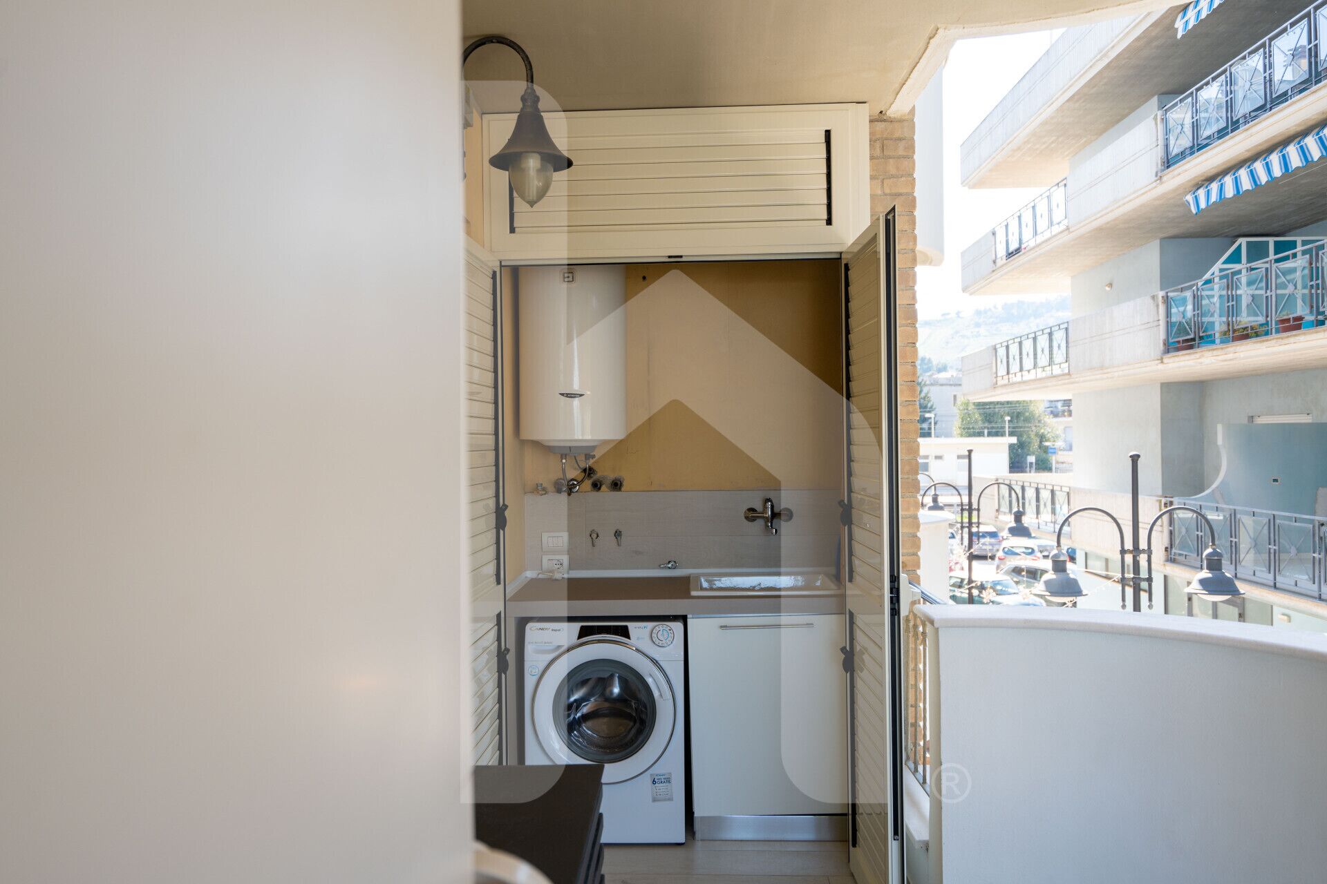 A compact laundry room with a washing machine, a dryer, and a sink.