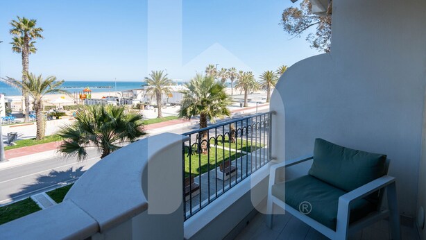 A balcony with a view of the beach, palm trees, and a clear sky. - Homiday - OLYMPUS Seafront Luxury (Roseto degli Abruzzi)