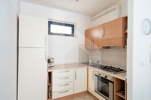 Een koelkast, een oven, kookgerei, borden en bestek