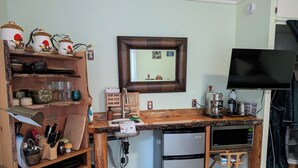 A compact kitchen with a wooden countertop, a sink, a refrigerator, and a coffee maker. - Island paradise with private hot tub -- pet friendly & breakfast included! (Pender Island)