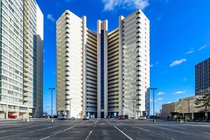 Un edificio moderno con un atrio central y varios pisos, rodeado por un estacionamiento.
