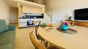 Een moderne leefruimte met een keuken, een eetgedeelte en een televisie.