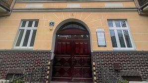 Een gebouw met een centrale ingang, meerdere ramen en balkons.