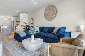 A modern living room with a sectional sofa, a coffee table, and a decorative wall piece.