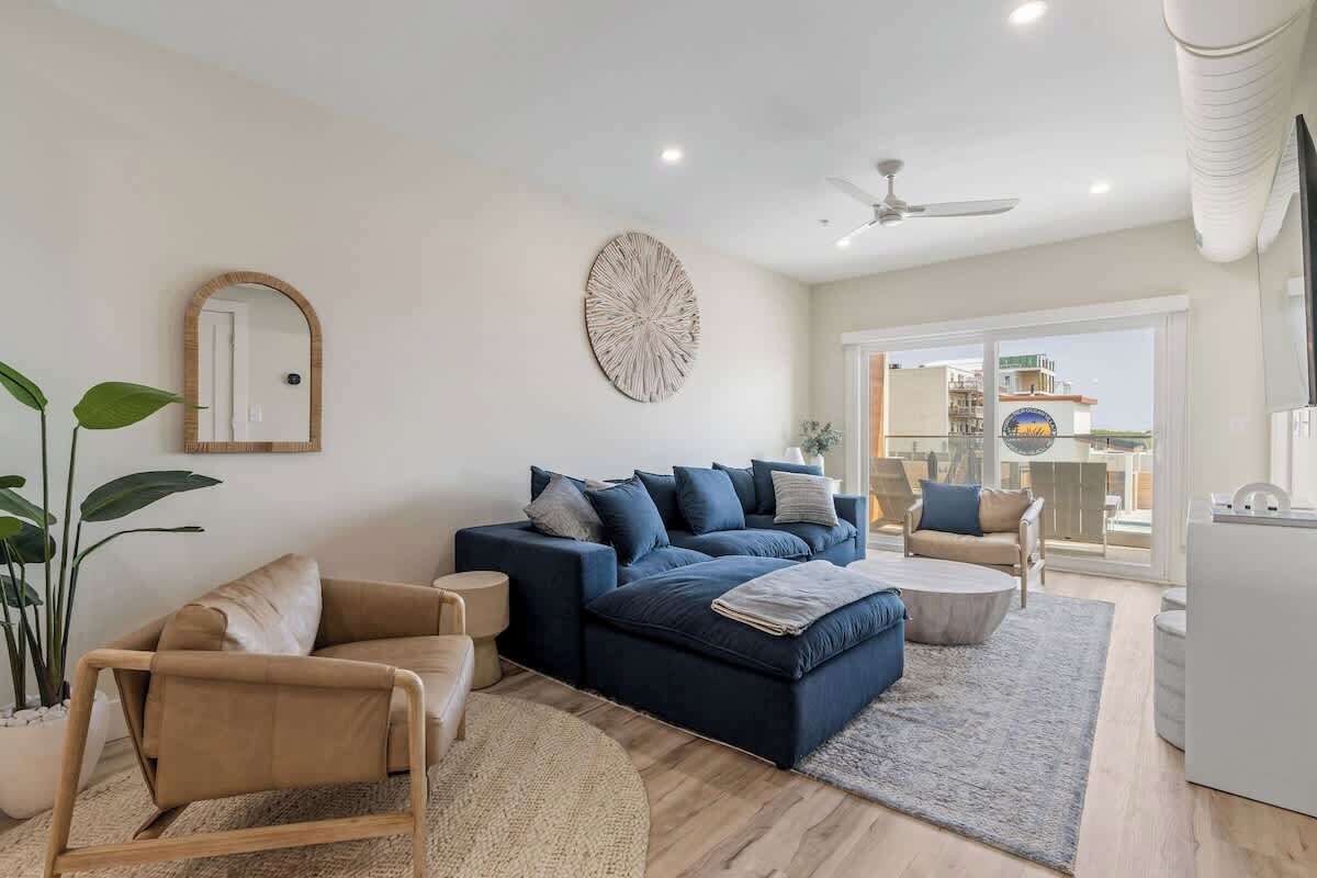 A modern living room with a sofa set, a coffee table, a side table, and a large mirror.