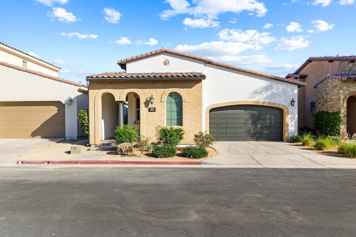 A residential property with a garage, a small entrance with a door, and a driveway.