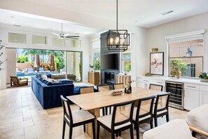 A spacious kitchen with a dining area, large windows, and a modern chandelier. - Twin Palms at PGA West, Heated Pool & Fire Pit (La Quinta)