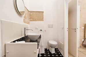 A bathroom with a white sink, a toilet, and a bathtub. - Xenia Old Town | Lecce Selection (Lecce)